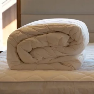 Washable Wool Comforter_Rolled View_On Washable Wool Mattress Pad_45th St Bedding