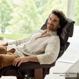 Reno Classic Chair & Ottoman_Noblesse Leather-Amarone_Walnut Finish_Lifestyle-Male Model_Stressless